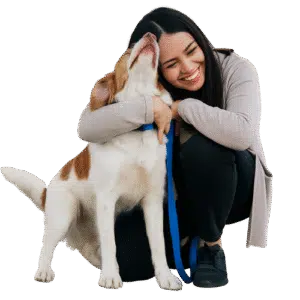Woman happily hugging her dog outdoors